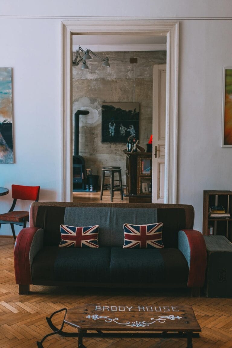 Interior of stylish living room with comfortable couch decorated with United Kingdom flag cushions and wooden furniture and floor
